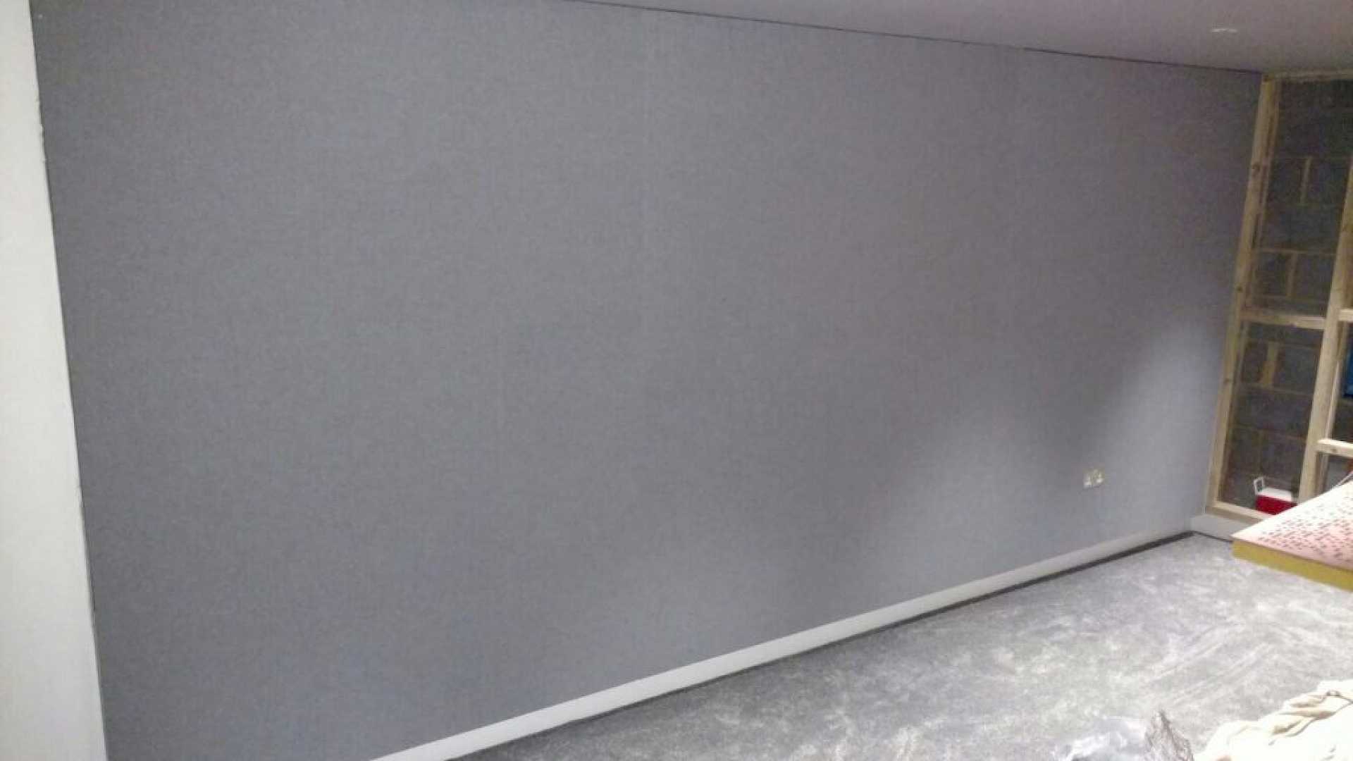 Shows grey stretched fabric covering the side wall and hiding the speaker and acoustic treatment.