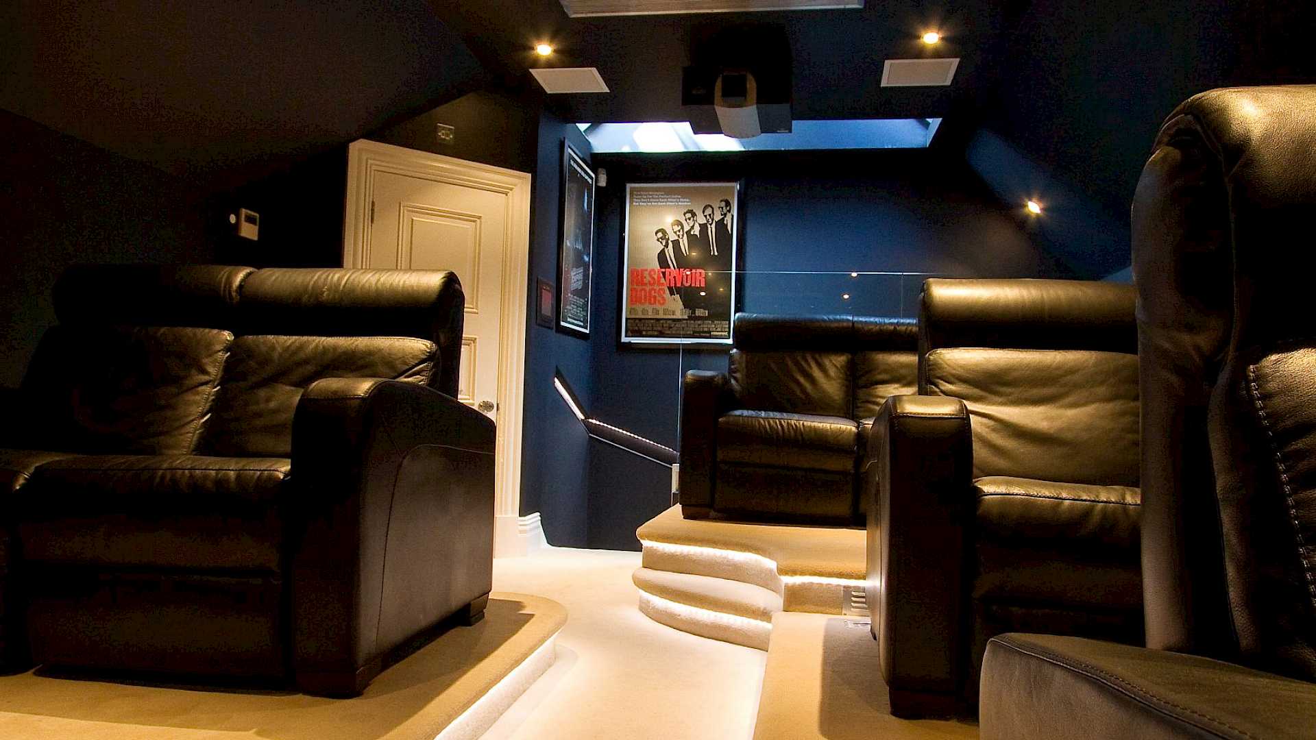 Image shows rear of home cinema with projector mounted on ceiling.