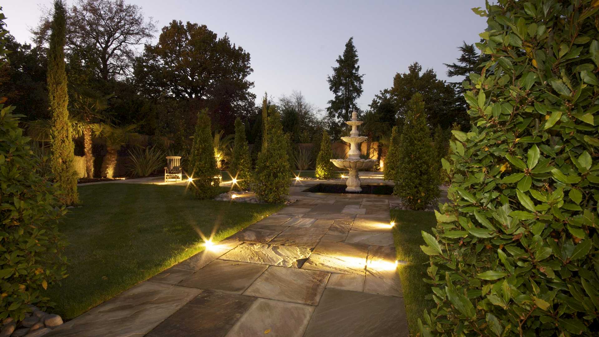 Garden with outside lighting, low level lights and accent light on fountain.