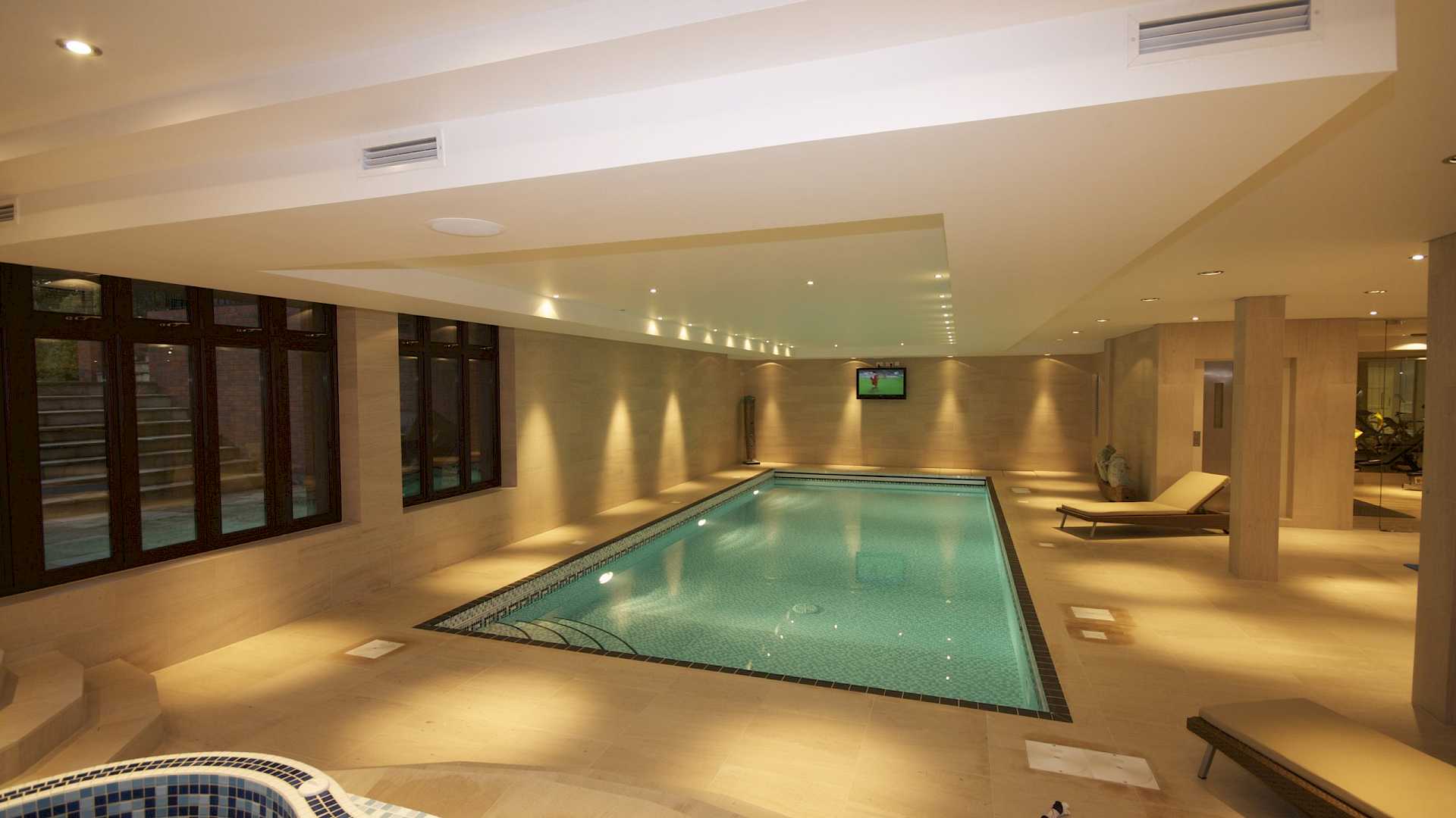 Smart home technology in pool area, shows lighting control, audio system and video distribution.