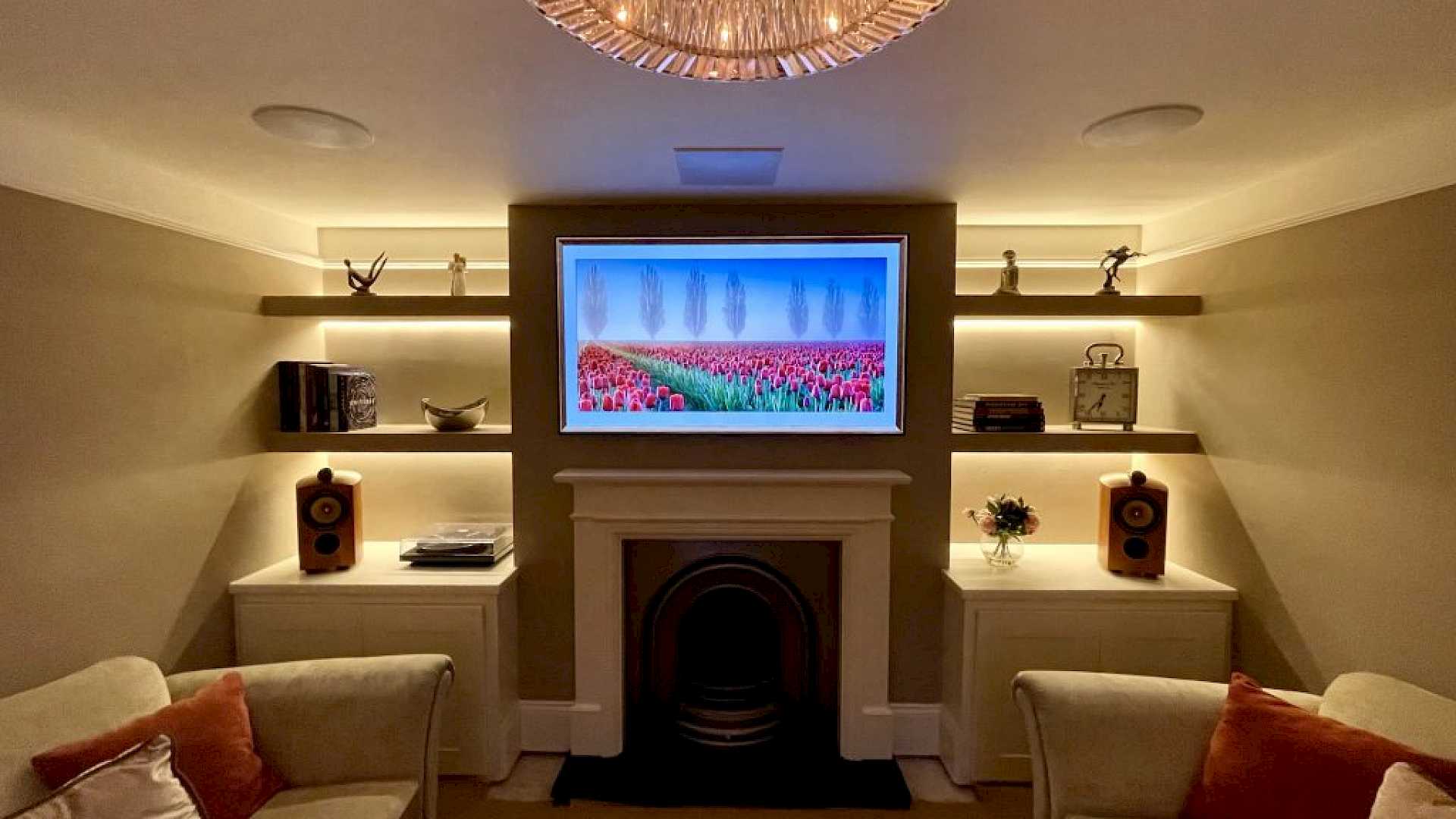Lutron lighting in home cinema media room, with TV above fireplace and in ceiling speakers